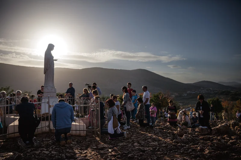 As the sun sets in Medjugorje, Bosnia and Herzegovina—a hot spot for Virgin Mary sightings—devotees of diverse faiths and nationalities gather to pray.