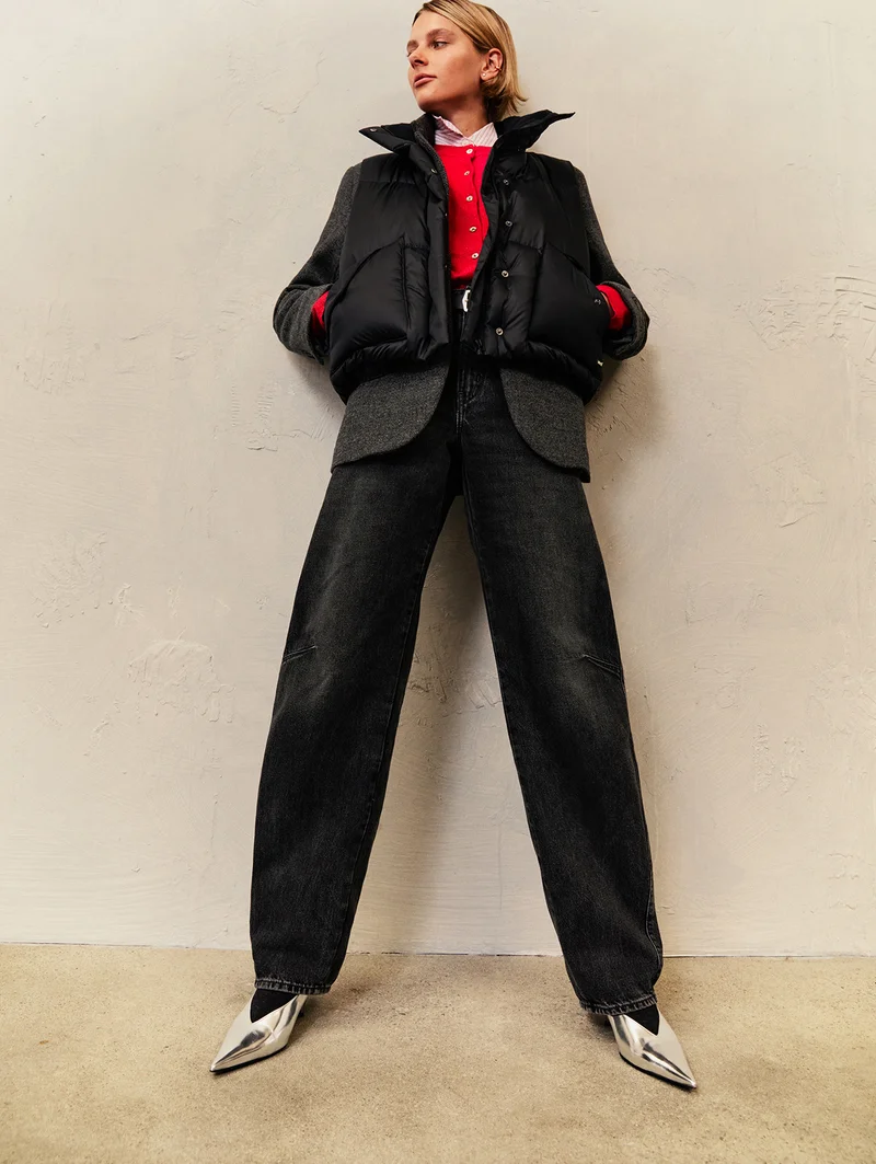 Person layering a red cardigan, coat, and puffer vest