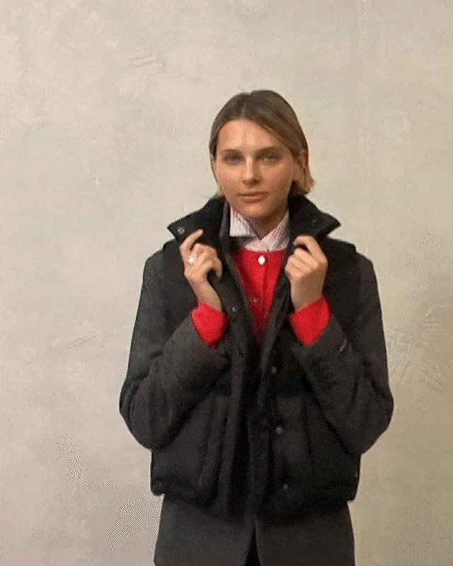 Gif of a person adjusting their puffer vest