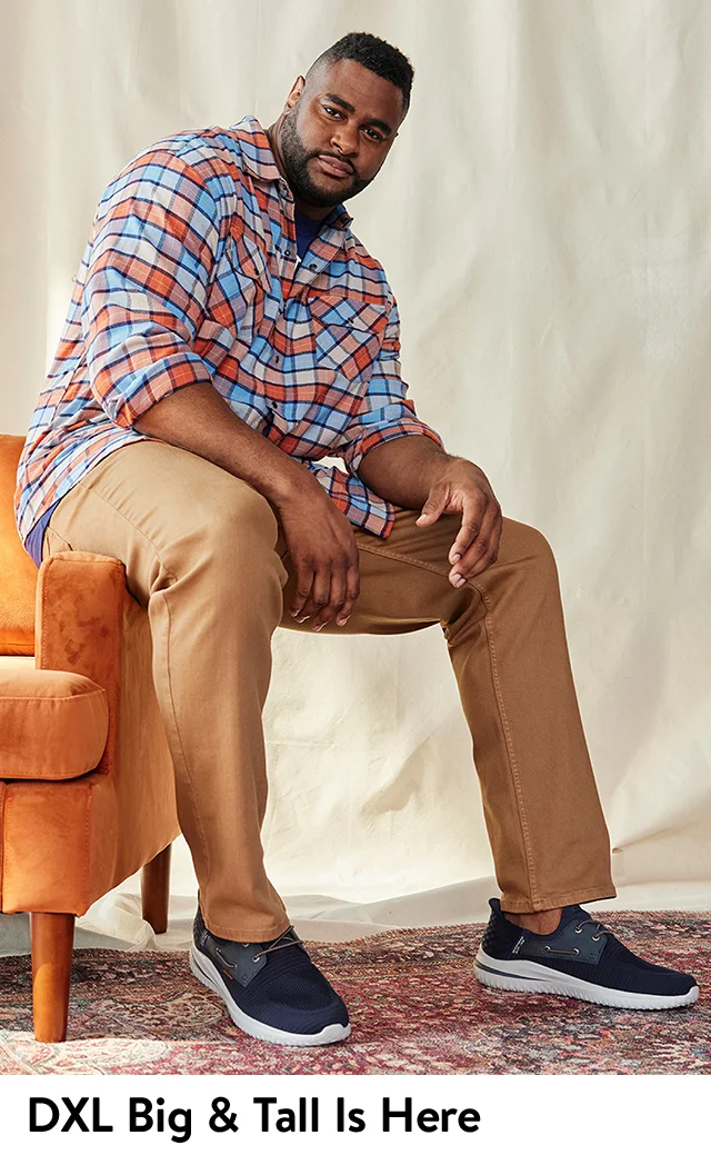 A man wearing a plaid shirt and tan pants.