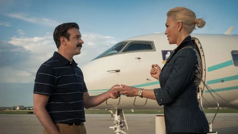 Image may contain: Jason Sudeikis, Hannah Waddingham, Adult, Person, Machine, Wheel, Aircraft, Airplane, and Transportation