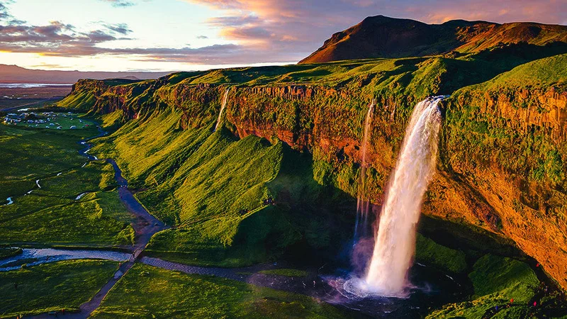 Image description: Aerial of Iceland's Seljalandsfoss waterfall during the Midnight Sun.