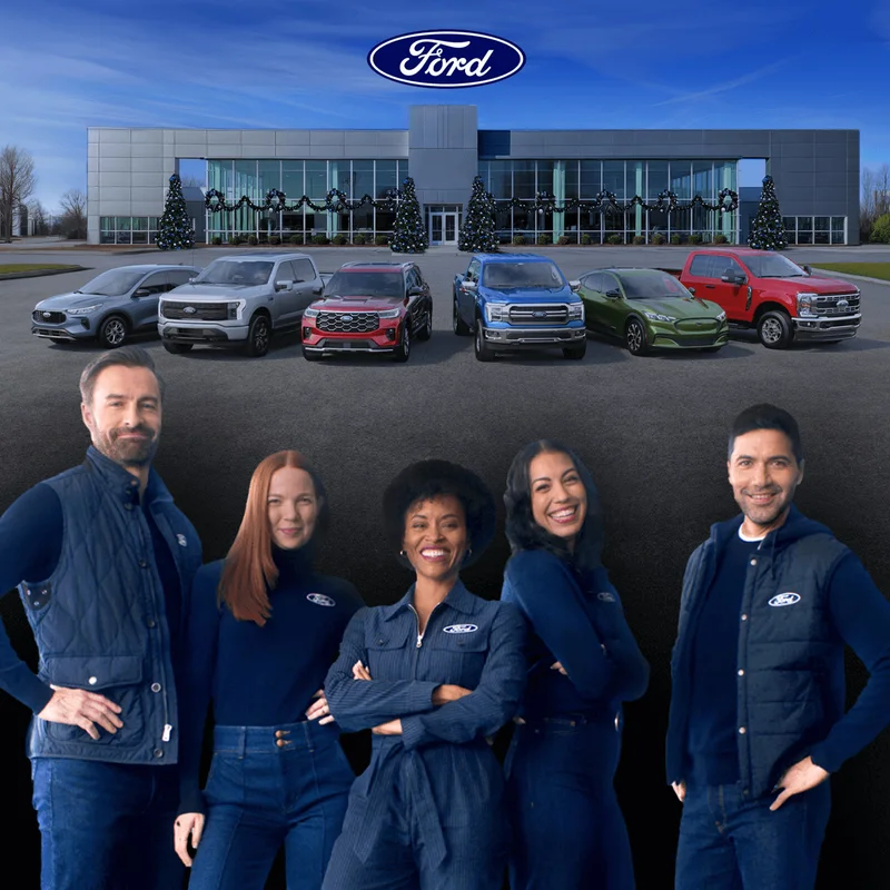 Six Ford vehicles parked in front of a Ford Dealership. Five Ford Crew members are in the foreground.