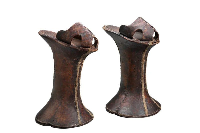 Pair of dark brown chopines rising 11⅞ inches and made from wood covered in leather.
