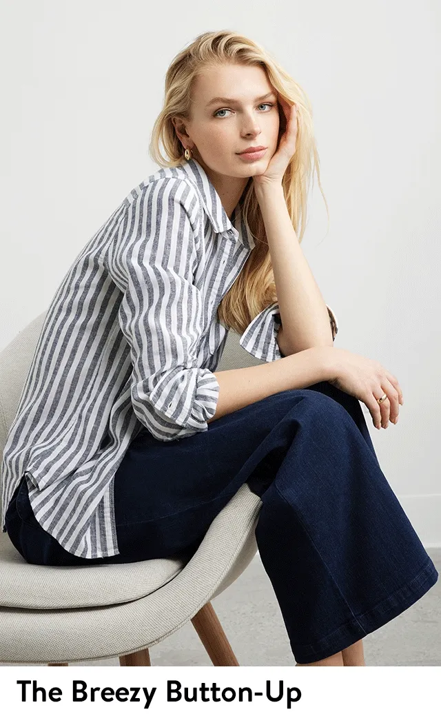 A woman wearing a striped button-up shirt with jeans.