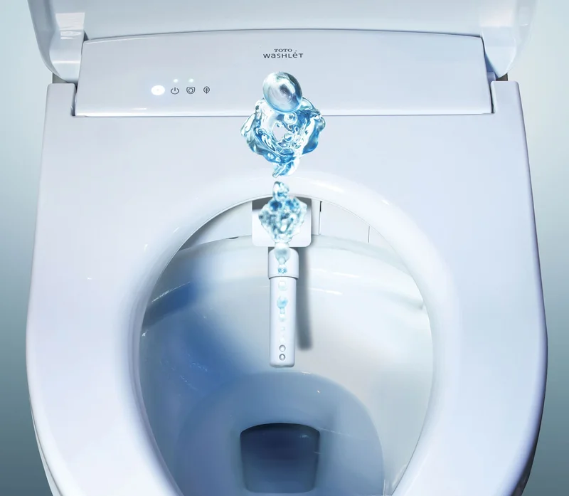 A TOTO WASHLET bidet seat is displaying its cleansing wand spray feature.