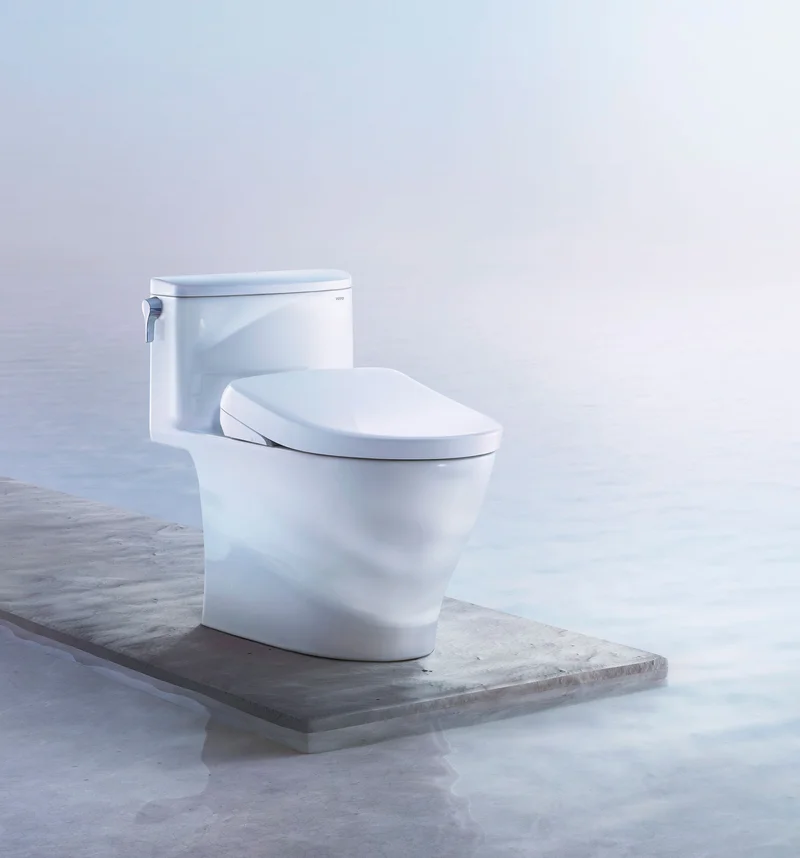A TOTO WASHLET S7 bidet seat is displayed on a platform above clear blue water.