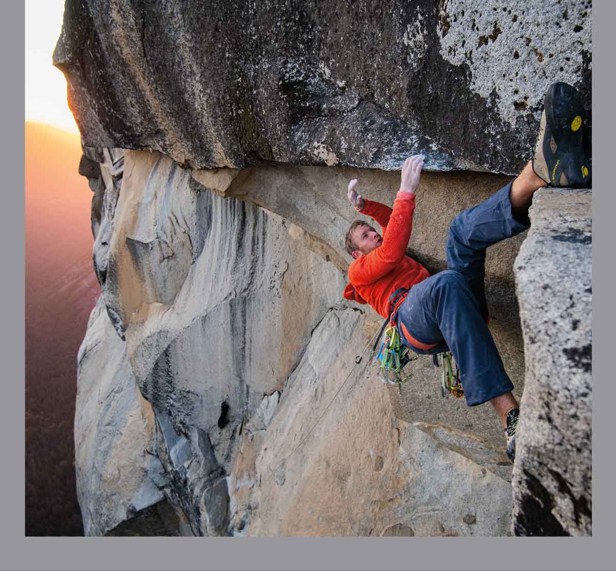 New Arrivals. A climber hooks a heel on the roof of a route high above the valley floor.