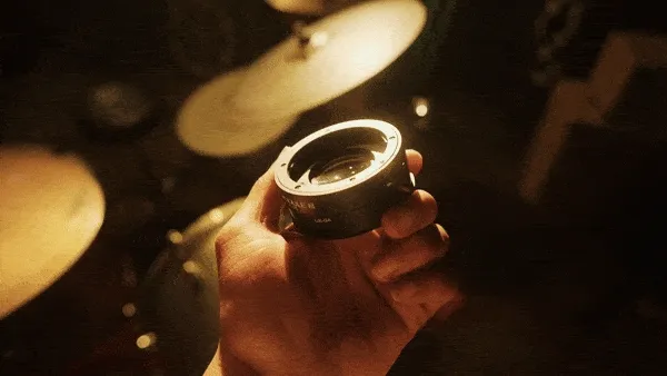 man spinning a lens in hard light in his hand