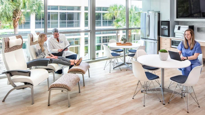 A group of four nested Fuld Chairs, all in different colors, next to an Olive Fuld Nesting Chair.