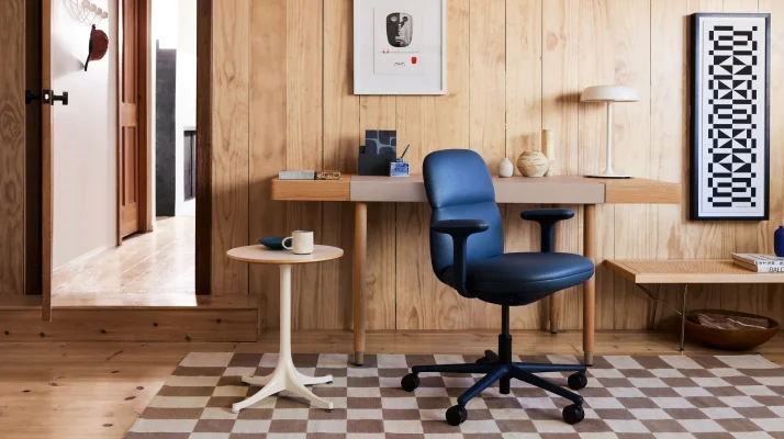Home office setting with an Asari Chair in Nightfall, designed by Naoto Fukasawa for Herman Miller; a Nelson Pedestal Table in light woodgrain top and white base designed by George Nelson for Herman Miller; and the Leatherwrap Sit-to-Stand Desk in Walnut and Champagne leather, designed by BassamFellows for Geiger.
