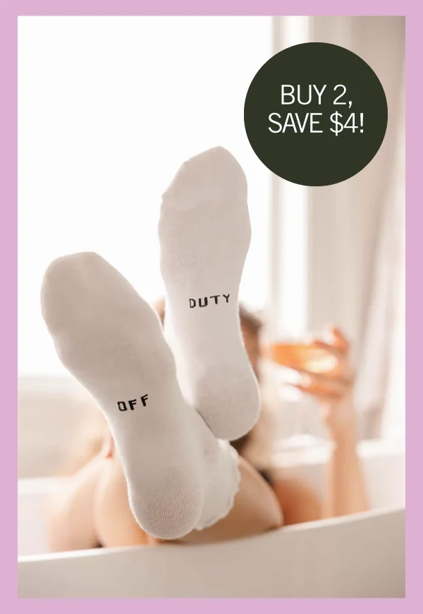 feet wearing white socks with 'off duty' written on the sole
