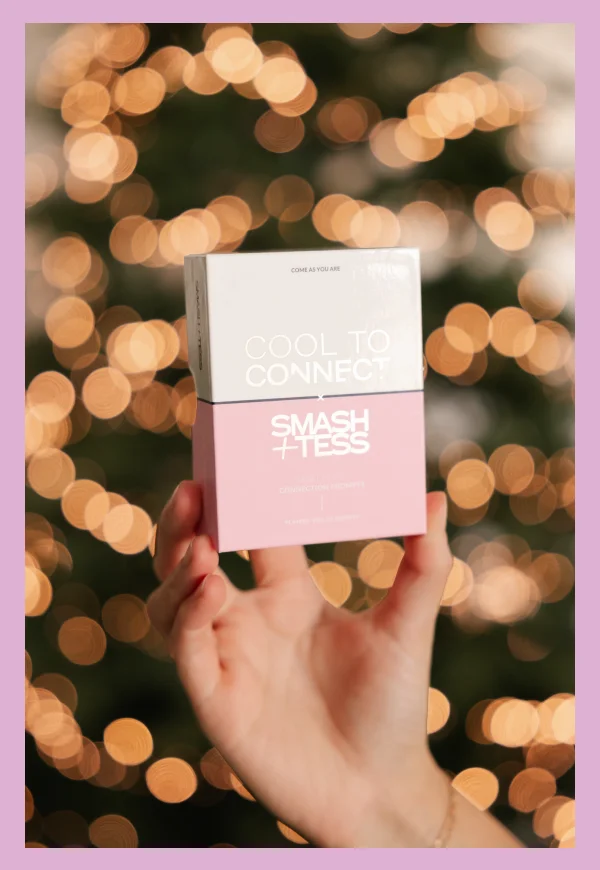 hand holding cool to connect cards in front of twinkling tree lights