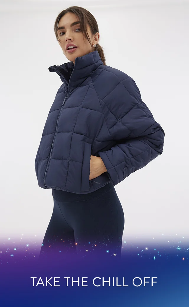 A woman wearing a navy puffer jacket and navy leggings.