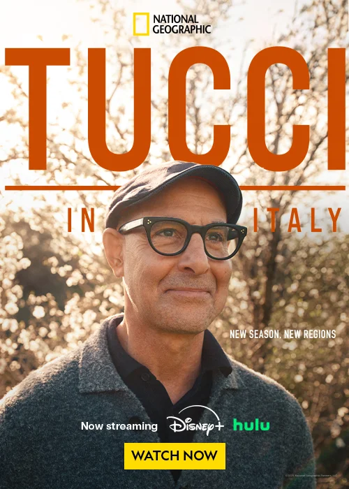 A man in a cap and glasses stands in front of a tree, promoting a new season of a show.