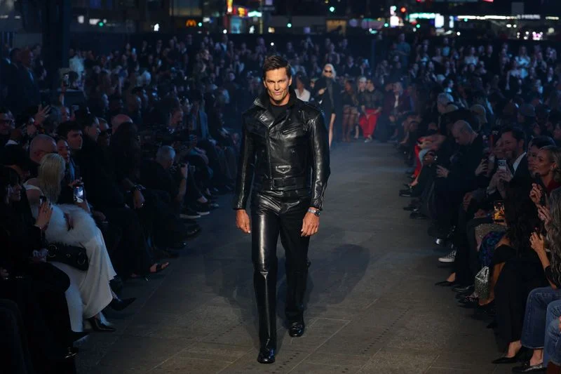 Image may contain: Tom Brady, La Parka, Clothing, Coat, Jacket, Adult, Person, Pants, Footwear, Shoe, High Heel, and Fashion