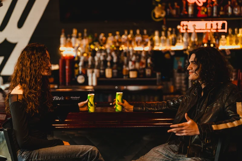 Two people sitting drink a Rebel Rabbit Lemon Lime