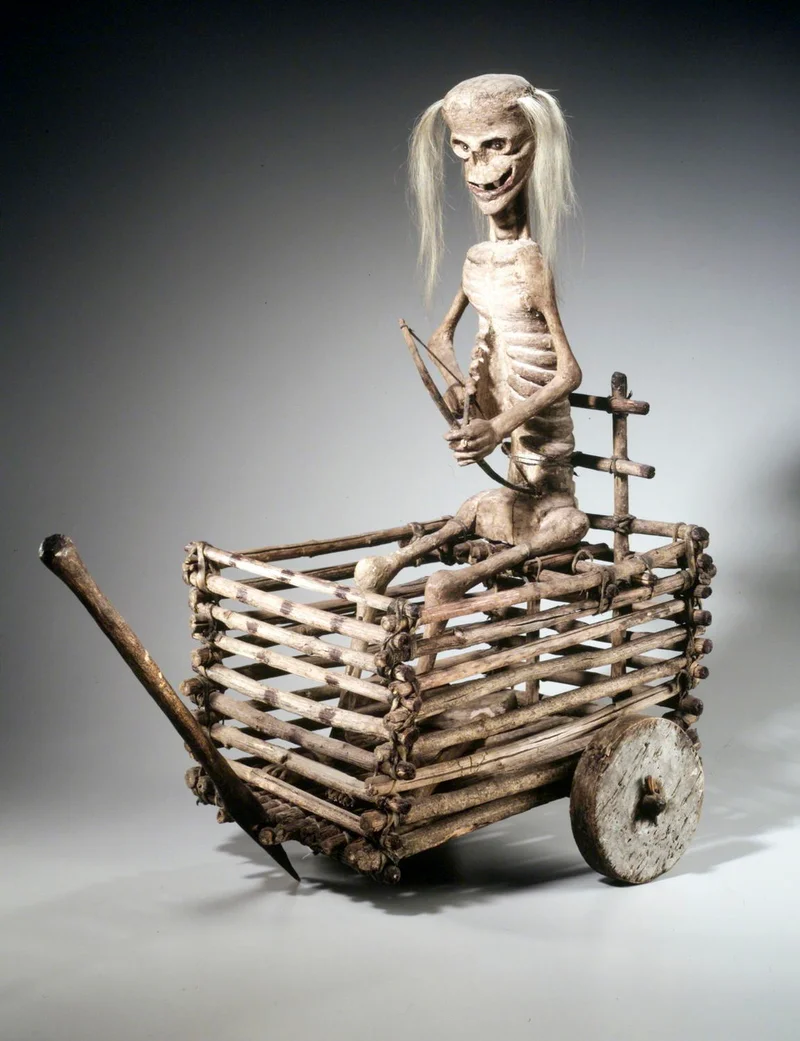 A sculpture of a skeleton riding a cart