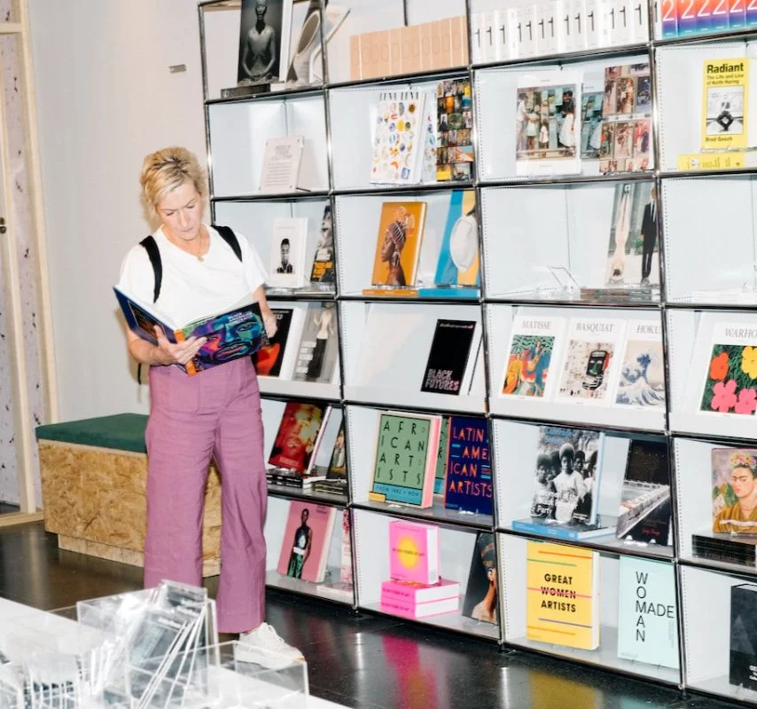 Woman reading a book while standing in a shop