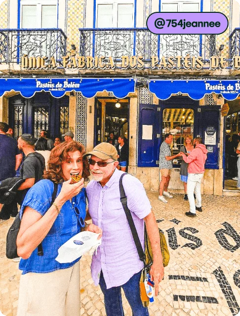 Image description: Two people posing with a custard tart outside of Pastéis de Belém, photo taken by @754jeannee.