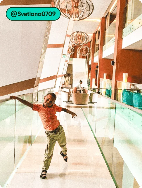 Image description: A child standing in a hotel lobby, photo taken by @Svetlana0709.