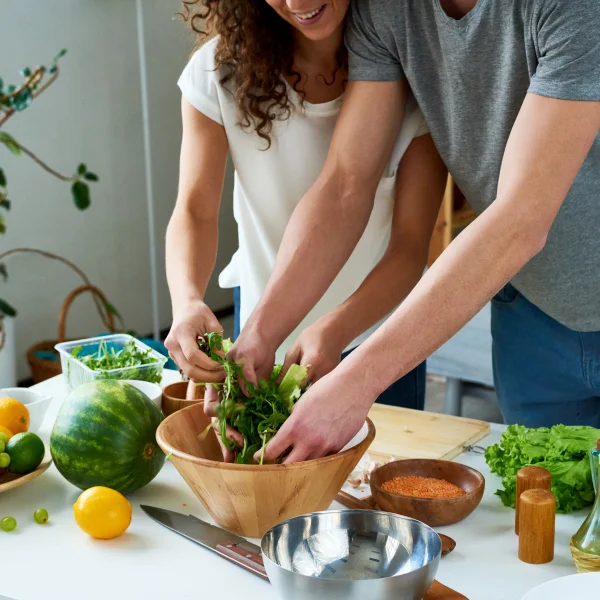 Man and Woman making a salad in a bowl