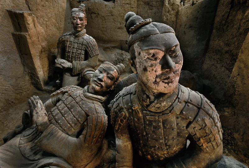 Three life-size, terracotta statues of soldiers.