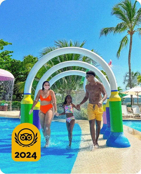Image Description: A family of three holding hands while walking through a shallow pool. A gold 2024 Travelers’ Choice Awards Best of the Best badge is on the bottom left corner of the image.