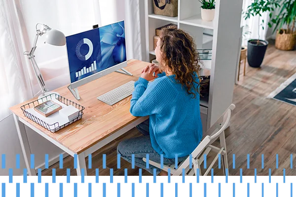 woman in blue sweater looking at computer