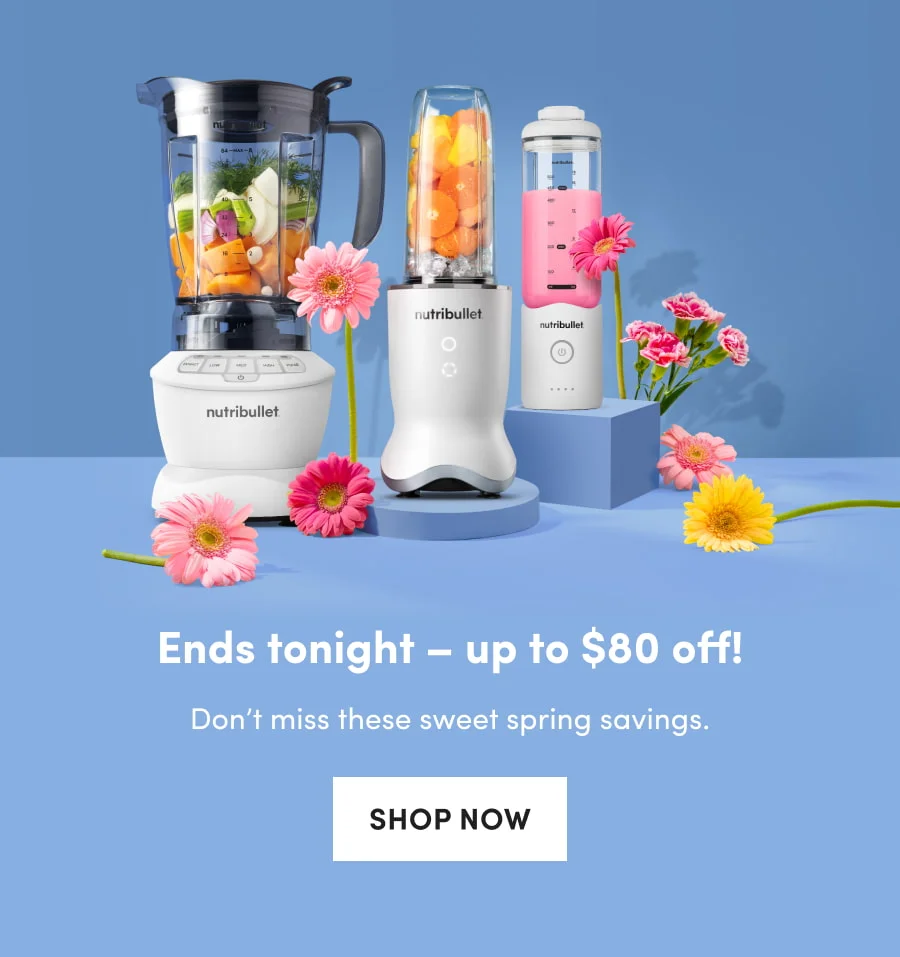 A studio shot of three different nutribullet blenders filled with fresh produce and smoothies, styled with vibrant pink and yellow flowers on blue pedestals.