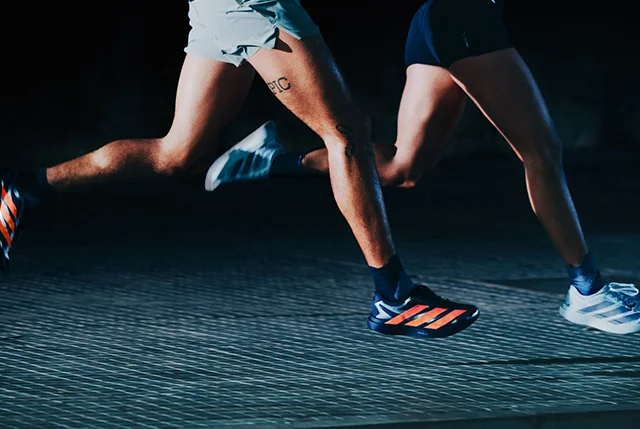 Two runners wearing the new ADIZERO EVO SL EXO running shoes