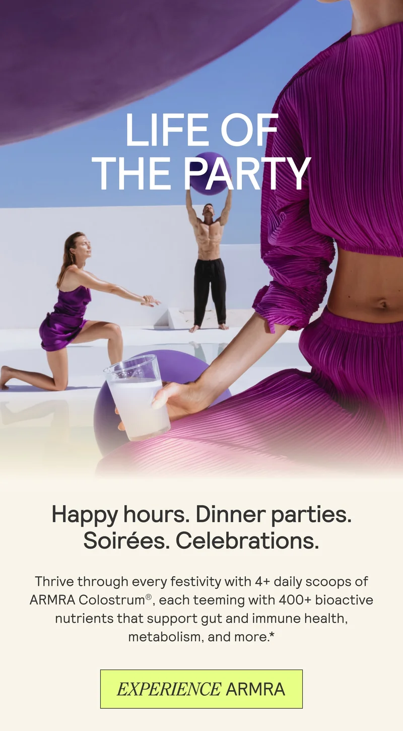 People in vibrant purple outfits posing around a modern white set, with the text ‘Life of the Party’ and a hand holding a glass of ARMRA colostrum.