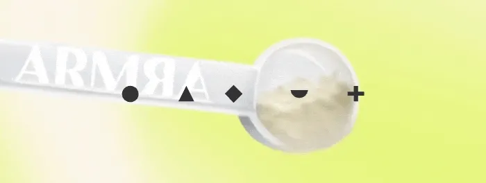Animated GIF of a scoop of ARMRA colostrum powder moving across a bright yellow background with geometric icons.