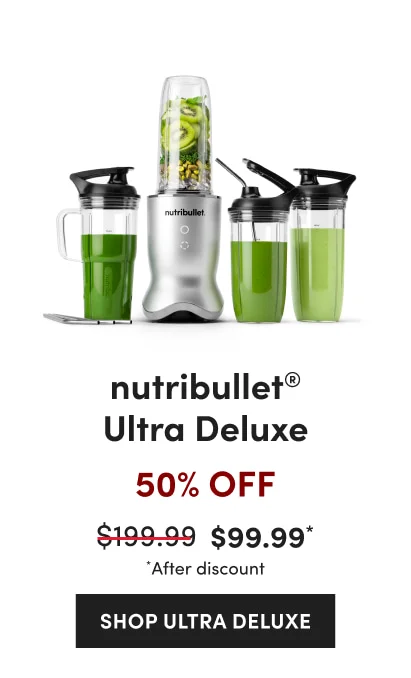 A silver nutribullet blender with a cup of kiwis and greens, flanked by three cups containing green smoothies, straw, and black lids.