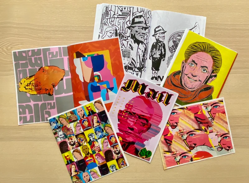 A photograph of zines on a wooden surface