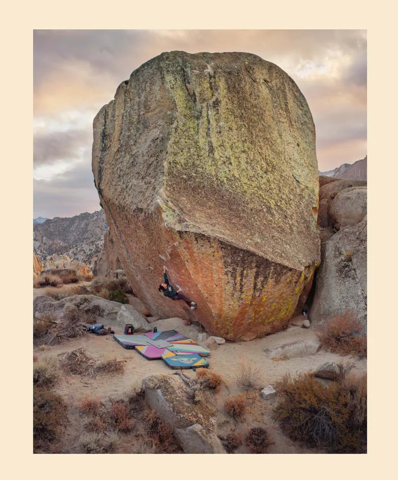 A person climbing on a boulder.