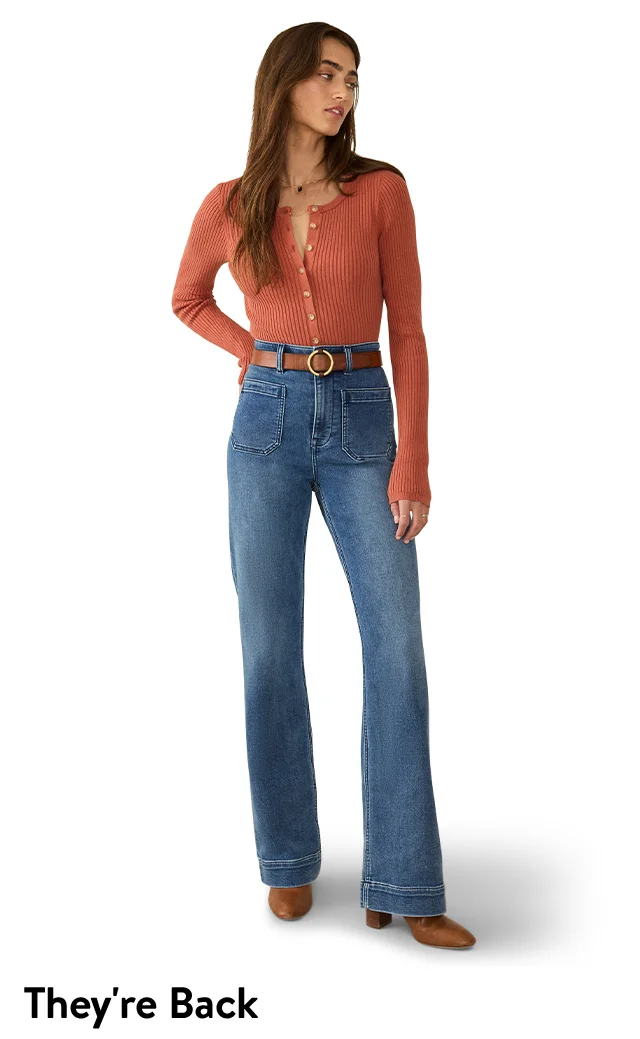 A woman wearing flare, high-waisted jeans with a long-sleeve top.