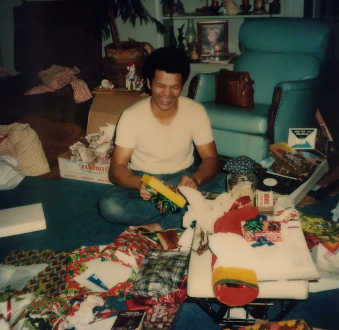 Person opening gifts in the living room