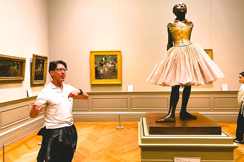 Image Description: A person standing next to a statue at an art museum.