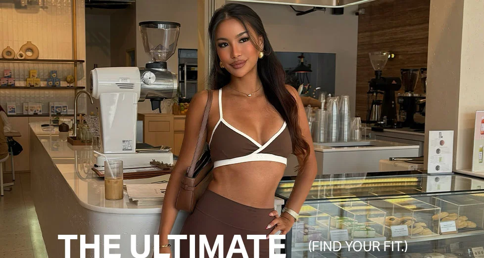 Fashionable woman in brown activewear sports bra & leggings, posing in a stylish cafe. Find your ultimate fit and comfort.