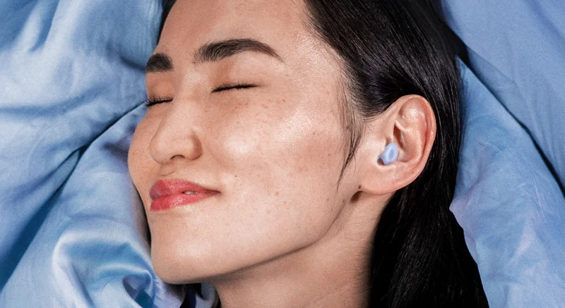 A woman peacefully sleeping with Dream Blue in her ears