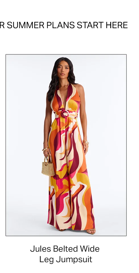 Woman models a vibrant Jules Belted Wide Leg Jumpsuit. Features a retro abstract pattern in orange, red, yellow, beige for summer fashion.