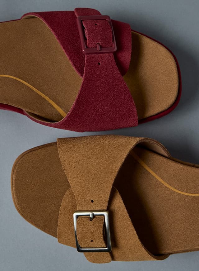 A close-up of the buckled strap on the Baminda wedge sandal in tan suede and burgundy suede.