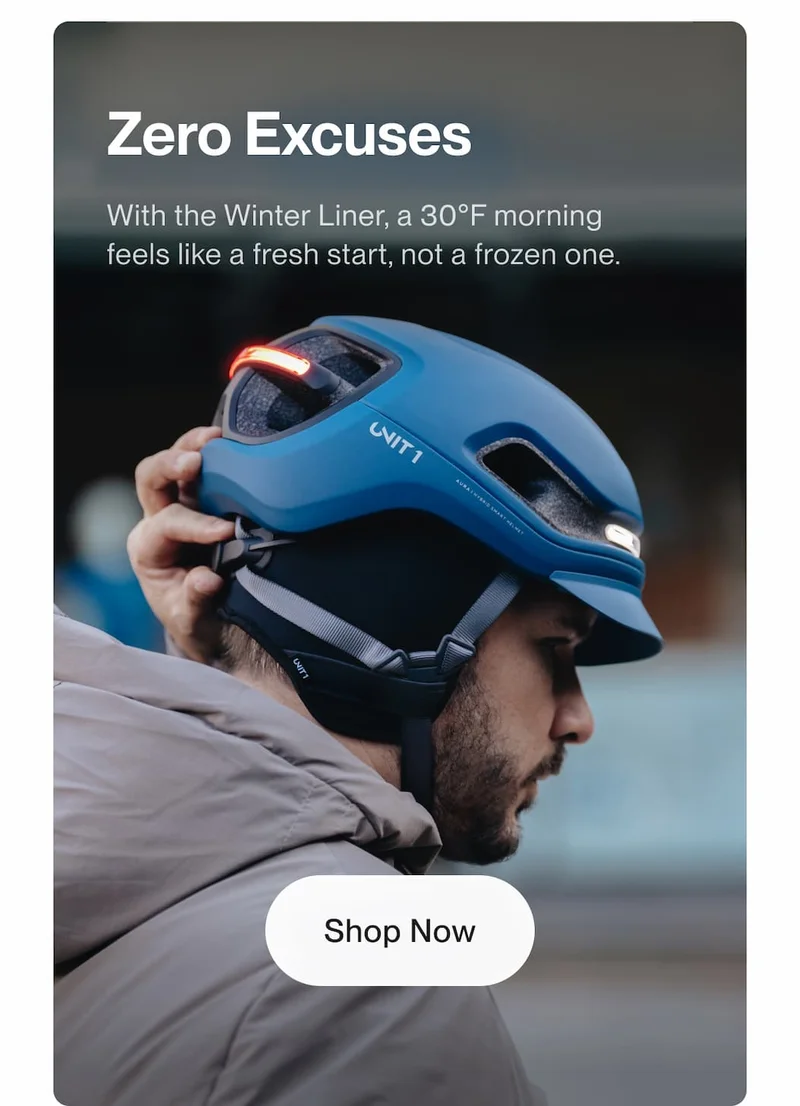 Cyclist adjusting a UNIT 1 smart helmet with a winter liner highlighting cold weather comfort and the headline Zero Excuses.