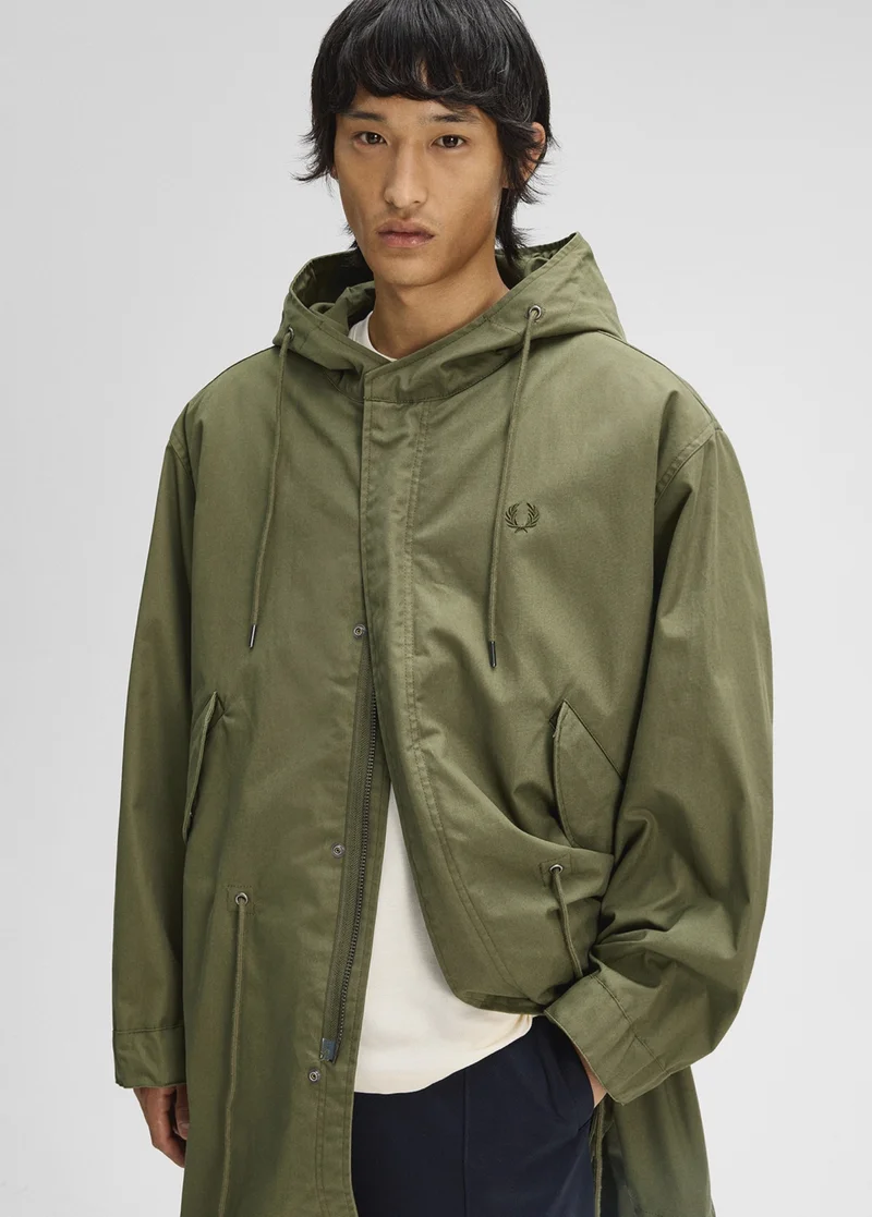 A male model wearing a Fred Perry Removable Liner Parka Jacket in Parka Green