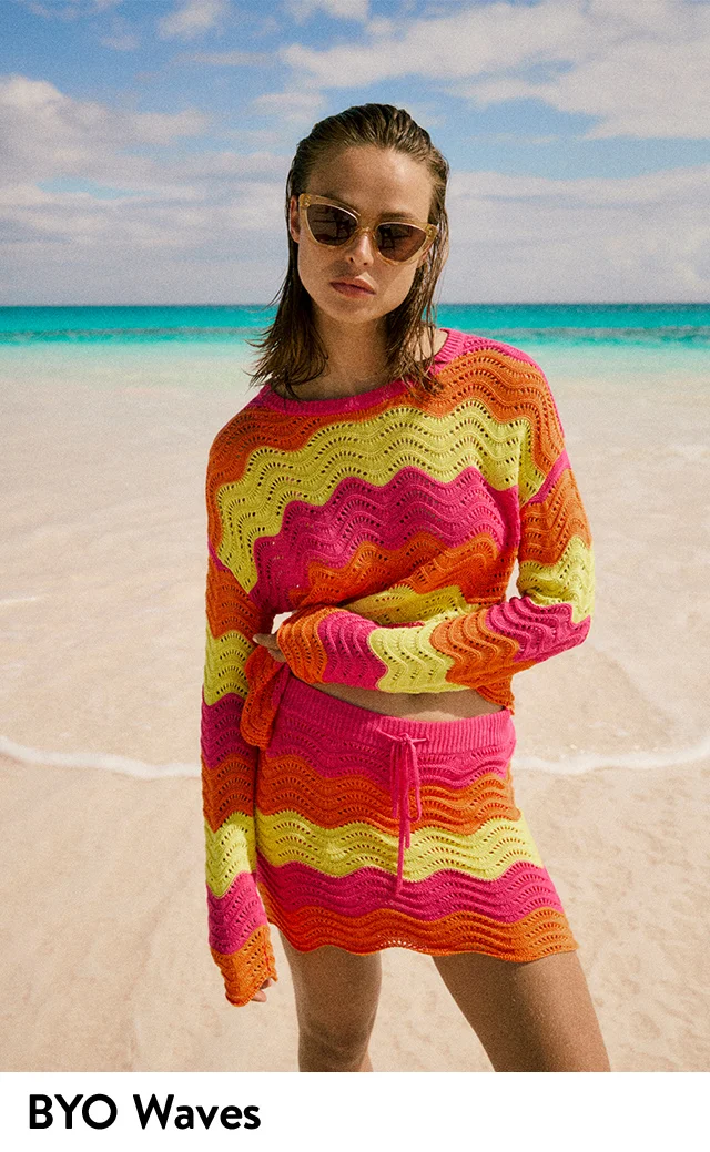 A woman wearing a bright zig-zag striped crochet top and matching skirt.