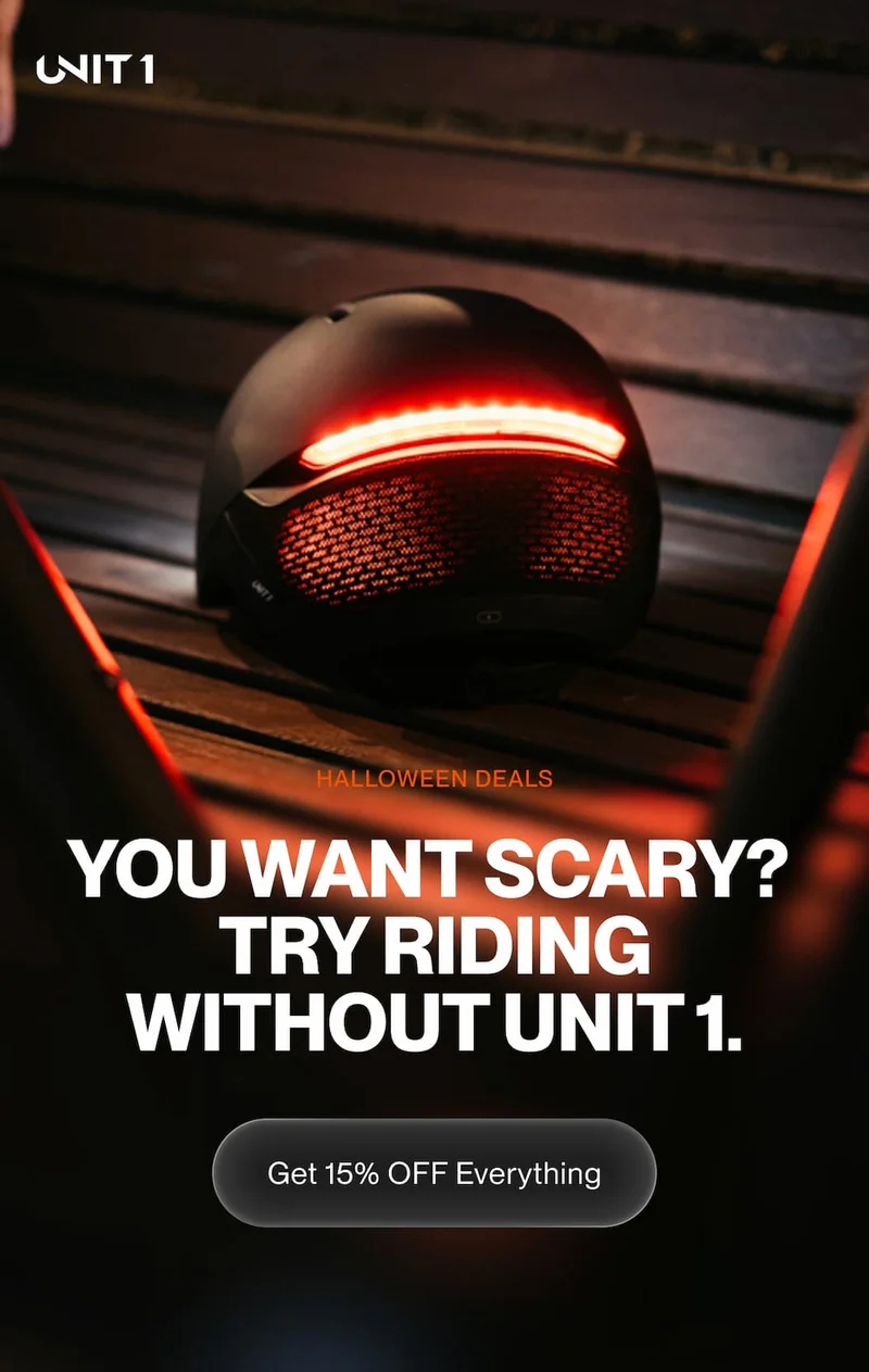 UNIT 1 smart helmet glowing red on a bench at night. Headline: You want scary? Try riding without UNIT 1.