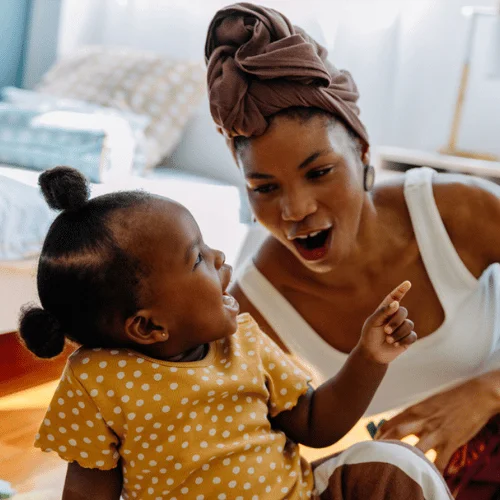 a toddler playing with mom
