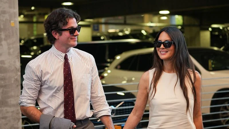 Image may contain: Olivia Munn, John Mulaney, Accessories, Formal Wear, Tie, Sunglasses, Glasses, Car, and Transportation