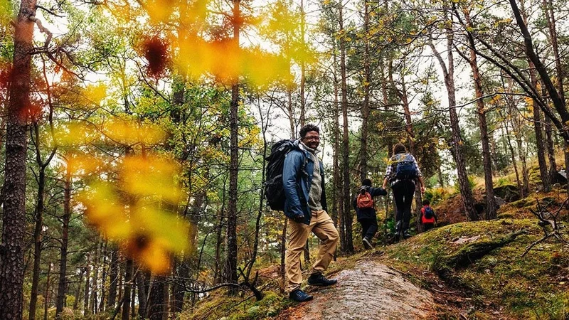 Image description: Family hiking together in the fall.